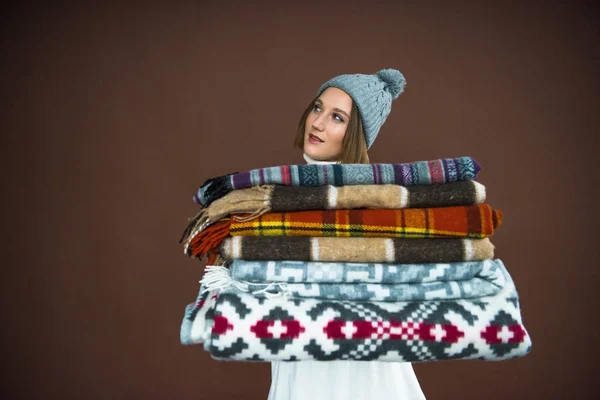 Woman holding pile of blankets — Stock Photo, Image