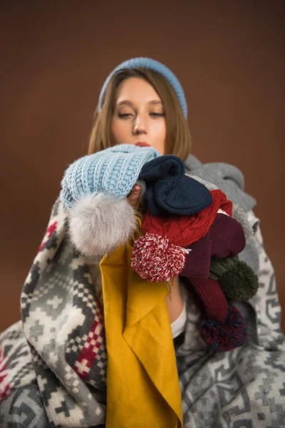 Menina segurando chapéus de inverno — Fotografia de Stock