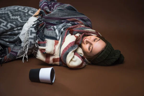 Kadın yerde yatarken battaniyelere sarılmış — Stok fotoğraf