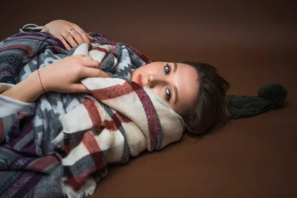 Ragazza sdraiata sul pavimento avvolta in una coperta — Foto Stock