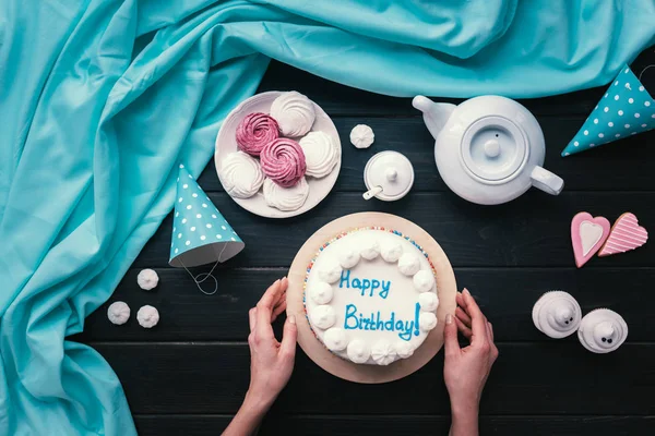 Kobieta, wprowadzenie tort urodzinowy na stole — Zdjęcie stockowe