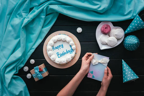 Жінка кладе листівку на стіл для дня народження — стокове фото