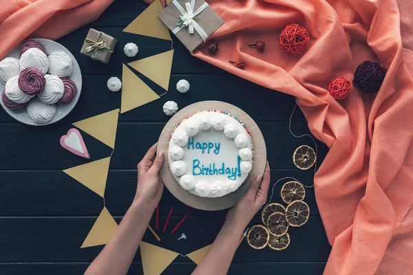 Mujer poniendo pastel de cumpleaños en la mesa —  Fotos de Stock