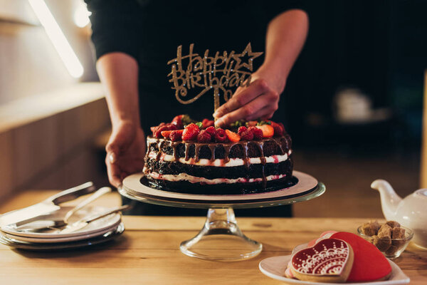 woman putting Happy Birthday sign