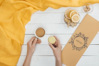 fincan çay ve ellerde macaron