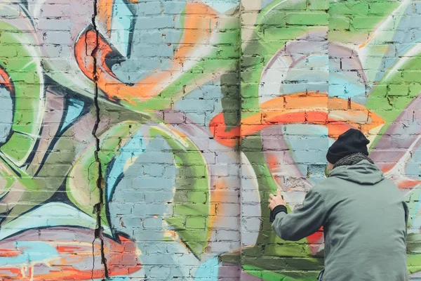 Visão Traseira Homem Pintando Graffiti Colorido Parede — Fotografia de Stock