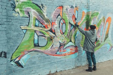 Sokak sanatçısı duvarlara renkli grafiti yapıyor.