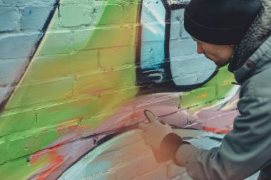 man painting colorful graffiti on wall clipart