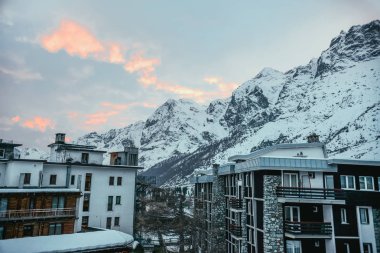 modern austrian town in mountains under sunset sky clipart