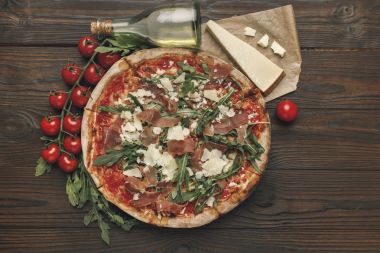 düz lay İtalyan pizza ve ahşap masa üzerinde çeşitli maddeler ile
