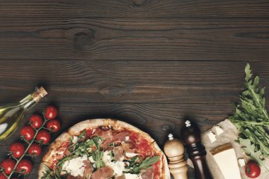 flat lay with italian pizza and various ingredients on wooden tabletop clipart