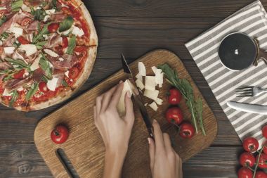 ev yapımı İtalyan pizza pişirme sırasında kadın kesme peynir kısmi görünümü
