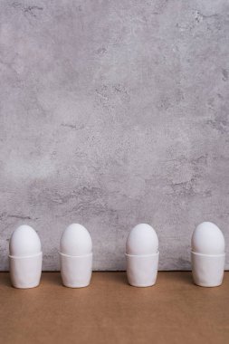 Satır bardak gri arka plan üzerinde beyaz yumurta