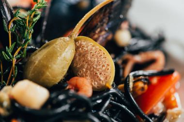 selective focus of gourmet spaghetti with cuttlefish ink, squid and mussels with octopus clipart