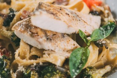 close-up view of delicious pasta with pike perch fillet, vegetables and parmesan cheese    clipart