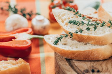 taze dilimlenmiş baget üzerinde ahşap kesme tahtası ve parmesan peyniri dolmalık biber ve mantar tablo ile görmek