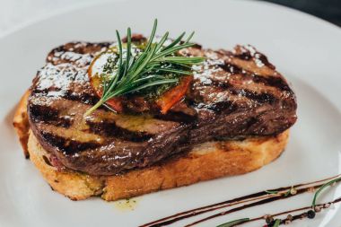 close-up view of delicious juicy beef steak with rosemary and roasted bread on plate  clipart