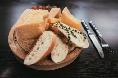 ahşap kesme tahtası üzerinde taze dilimlenmiş baget ve parmesan peyniri