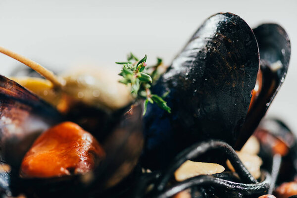 selective focus of delicious spaghetti with cuttlefish ink, squid and mussels with octopus 