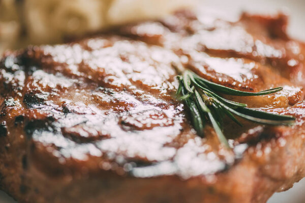 close-up view of fresh hot juicy beef steak with rosemary 