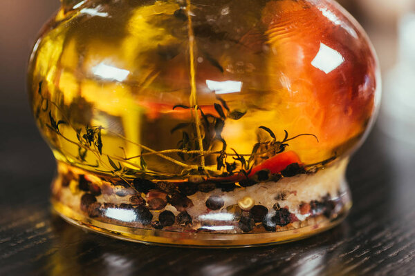 close-up view of extra virgin oil with spices in glass bottle