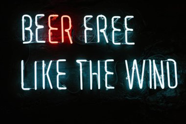 beer free like the wind neon inscription on dark wall in bar clipart