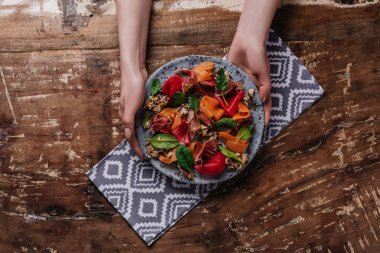 midye, sebze ve jamon salatası ile plaka holding eller kadeh kırpılmış