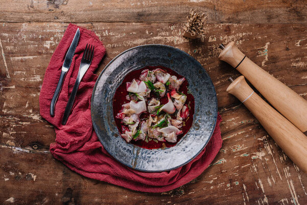top view of delicious ceviche with Dorado and daikon in plate on wooden table 