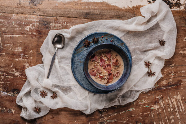 top view of fresh gourmet cream soup with fried potatoes and jamon