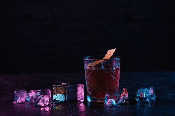 close-up view of glass with delicious alcoholic boulevardier cocktail and ice cubes 