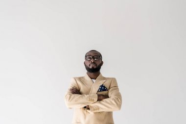 çapraz kolları ile ayakta ve gri izole kamera bakarak emin şık Afro-Amerikan bir adam portresi
