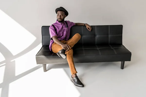 Reflexivo Afroamericano Hombre Moda Descansando Sofá Negro Sobre Fondo Gris — Foto de Stock