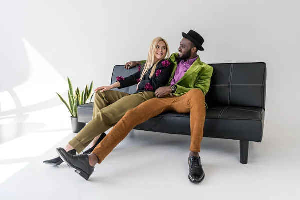 Alegre Casal Multicultural Elegante Descansando Sofá Preto Fundo Cinza — Fotografia de Stock