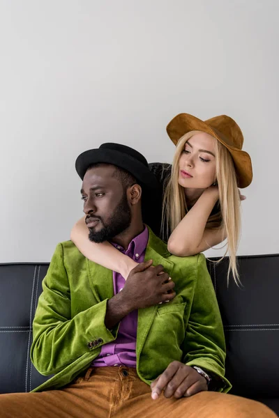 Caucasiano Mulher Abraçando Elegante Afro Americano Namorado Sofá Isolado Cinza — Fotografia de Stock