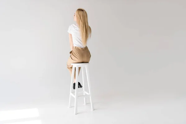 Vue Arrière Femme Blonde Élégante Assise Sur Tabouret Sur Gris — Photo