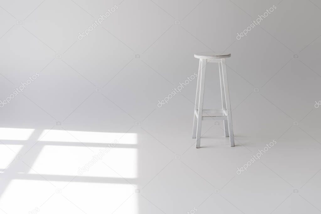 single empty modern white stool on grey