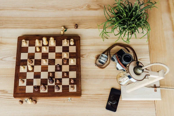 Chess board set with old camera — Stock Photo