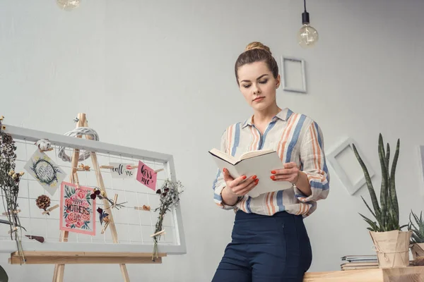 Empresária com livro no local de trabalho — Fotografia de Stock