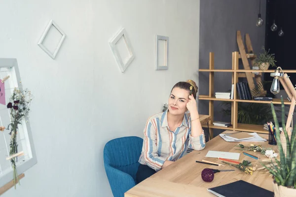 Fleuriste avec des fleurs sur le lieu de travail — Photo de stock