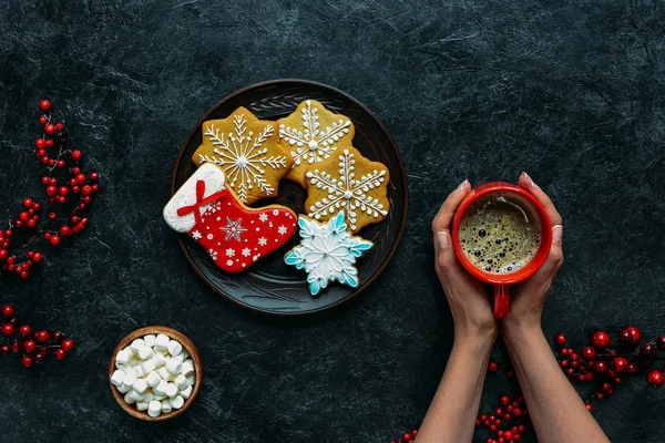 Manos con pan de jengibre de Navidad y café - foto de stock