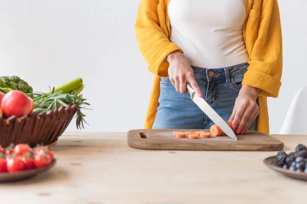 Женщина режет морковь — стоковое фото
