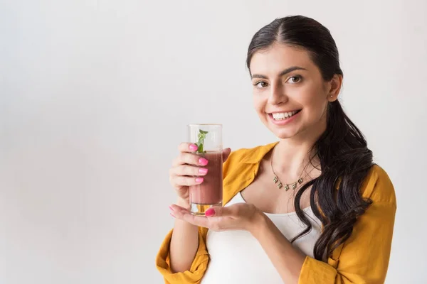 Улыбающаяся женщина показывает детоксикационный напиток — стоковое фото