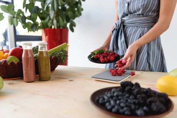 Femme pondération framboises — Photo de stock