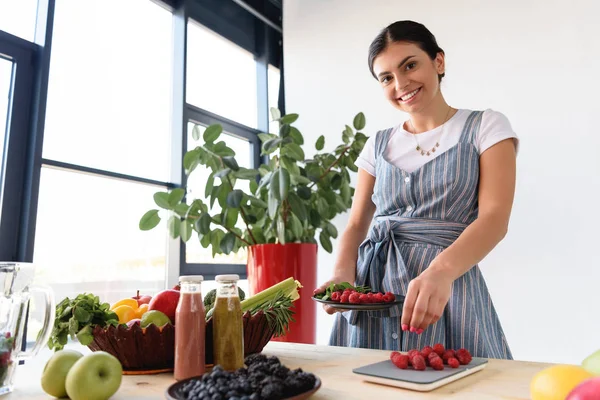 Femme pondération framboises — Photo de stock