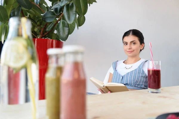 Mulher leitura livro à mesa — Fotografia de Stock