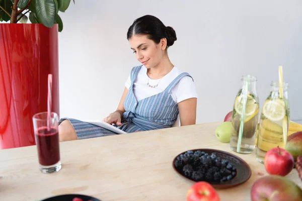 Woman reading book at table — Stock Photo