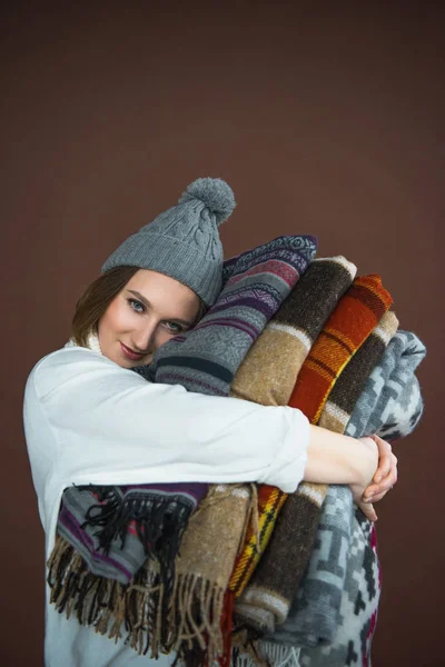 Woman holding pile of blankets — Stock Photo