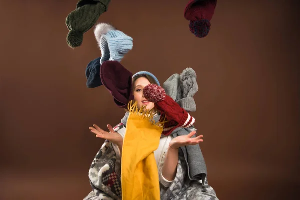 Woman throwing up winter hats — Stock Photo