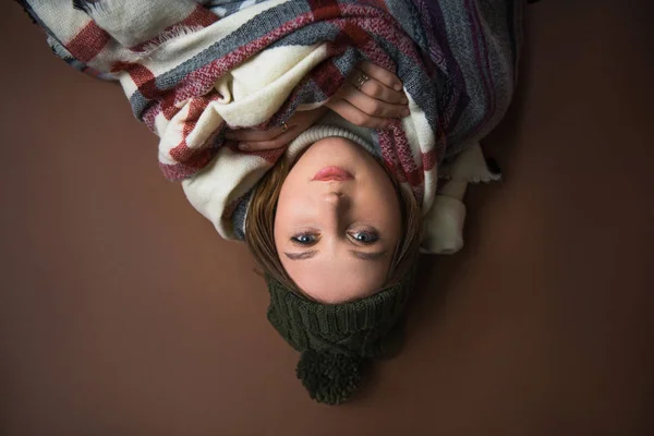 Girl lying on floor wrapped in blankets — Stock Photo