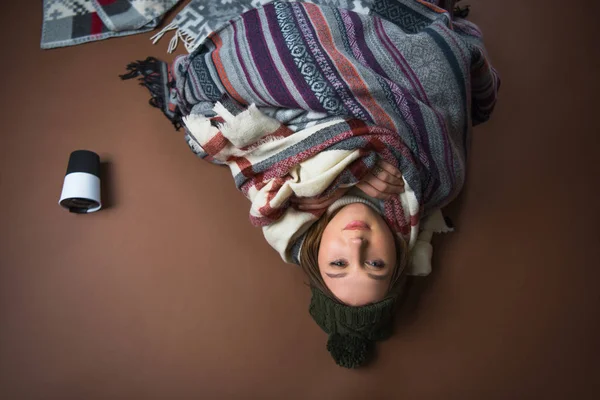 Девушка лежит на полу завернутая в одеяла — стоковое фото